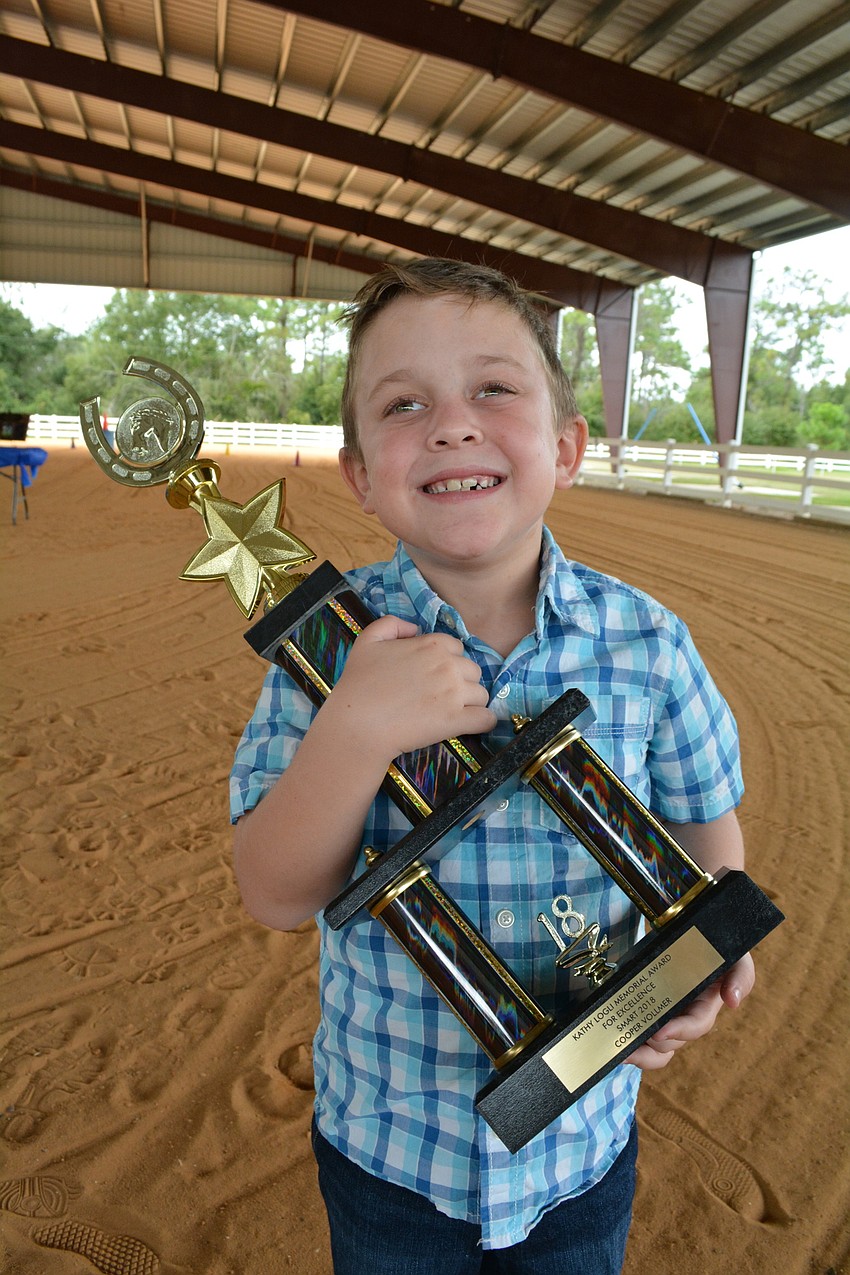 SMART rider Cooper Vollmer shows off the trophy he earned as this year's recipient of the Kathy Logli Memorial Award for Excellence. He says it is the biggest of all his trophies.