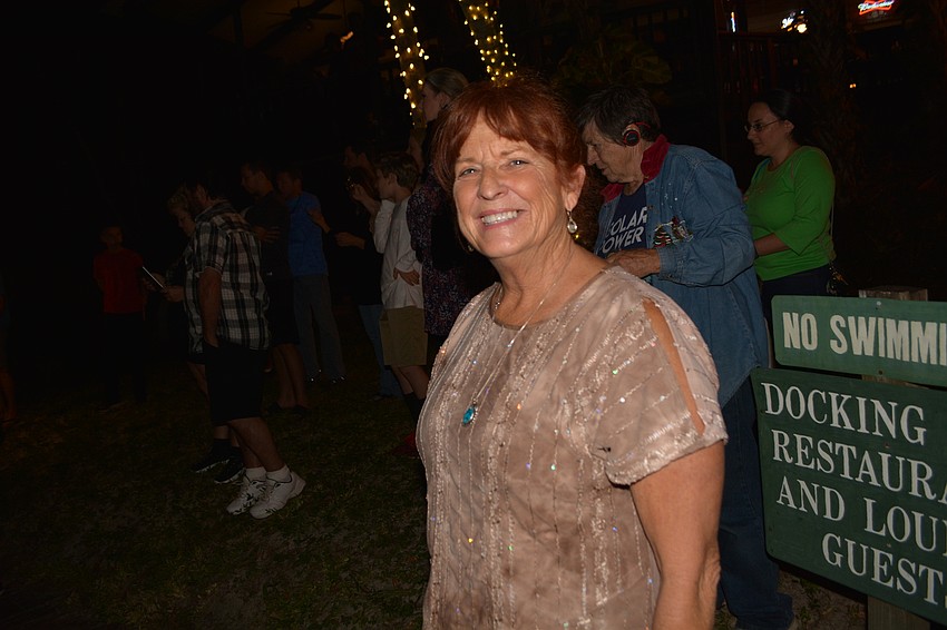 Barbara Vandernoord, of Bradenton, comes out from the restaurant when the boats get into sight.