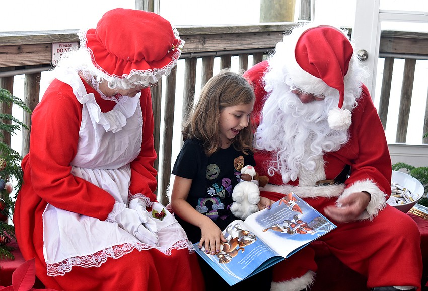 Madison King reads a story with Santa and Mrs. Claus.
