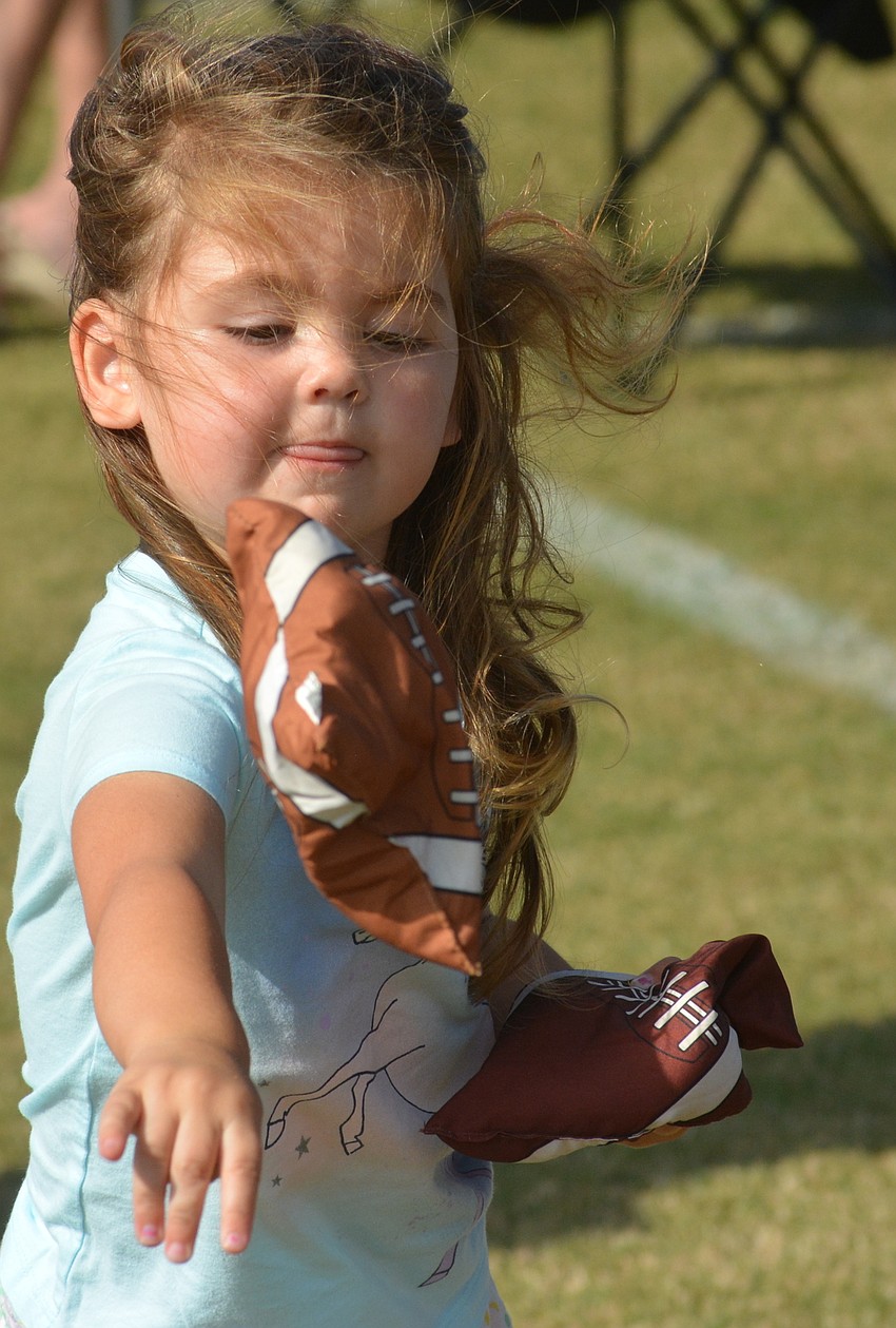 Kenna McSherry, 2, plays a little bean bag toss before the polo match.