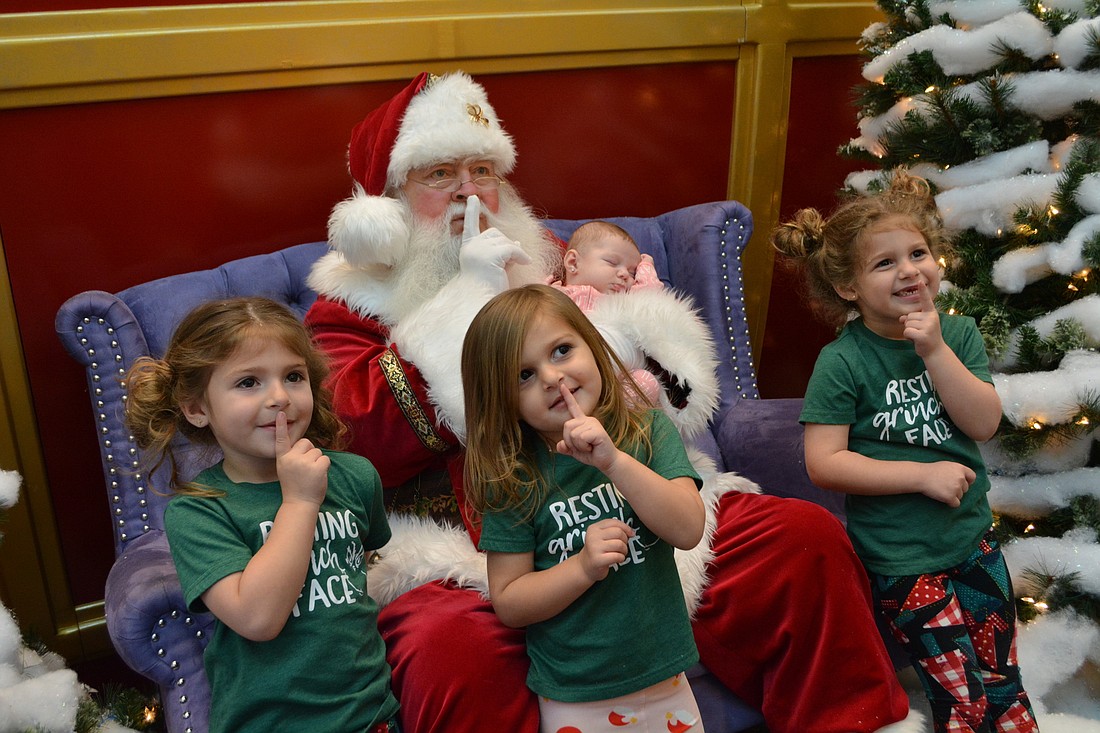 At the Mall at University Town Center, Santa teaches  Olivia, Noor and Zaynab Kazbour how to be quiet while baby sister, Layaal, sleeps. "It&#39;s so cute I can&#39;t stand it," says their mom, Parrish&#39;s Jordan Kazbour.