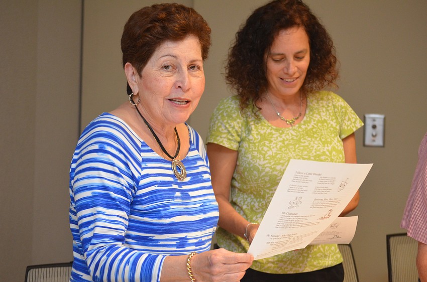 Toby Halpern and Dori Goldfarb sing the blessings to the menorahs as they're lit.