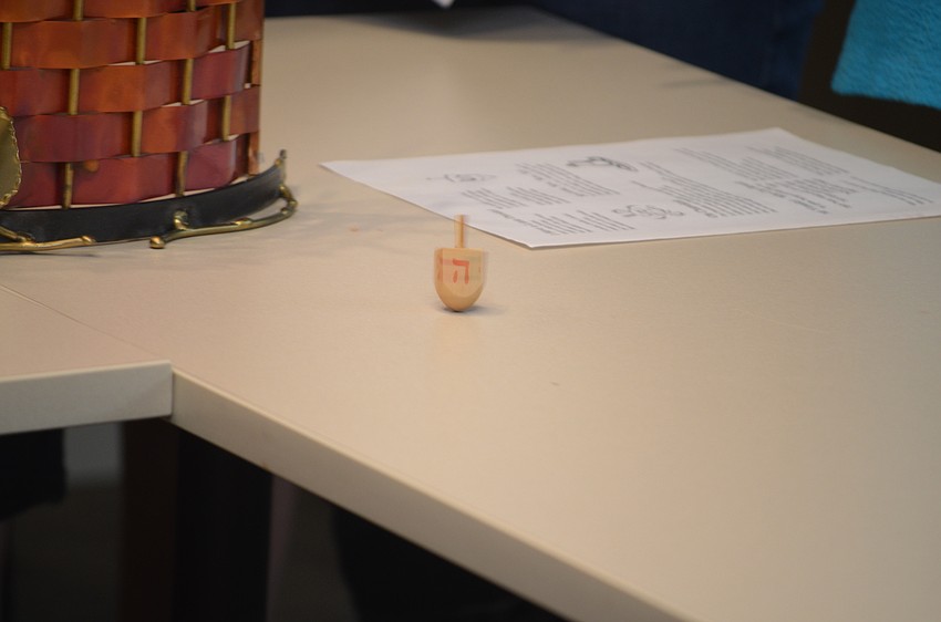 The dradel spins as attendees sing the Dreidel song.