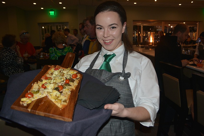 Waitress Tiffany Dittus brings the crowd artichoke and Boursin cheese flatbread.