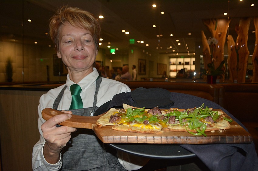 Waitress Irene Nabatou lets the guests taste the steak and eggs flatbread.