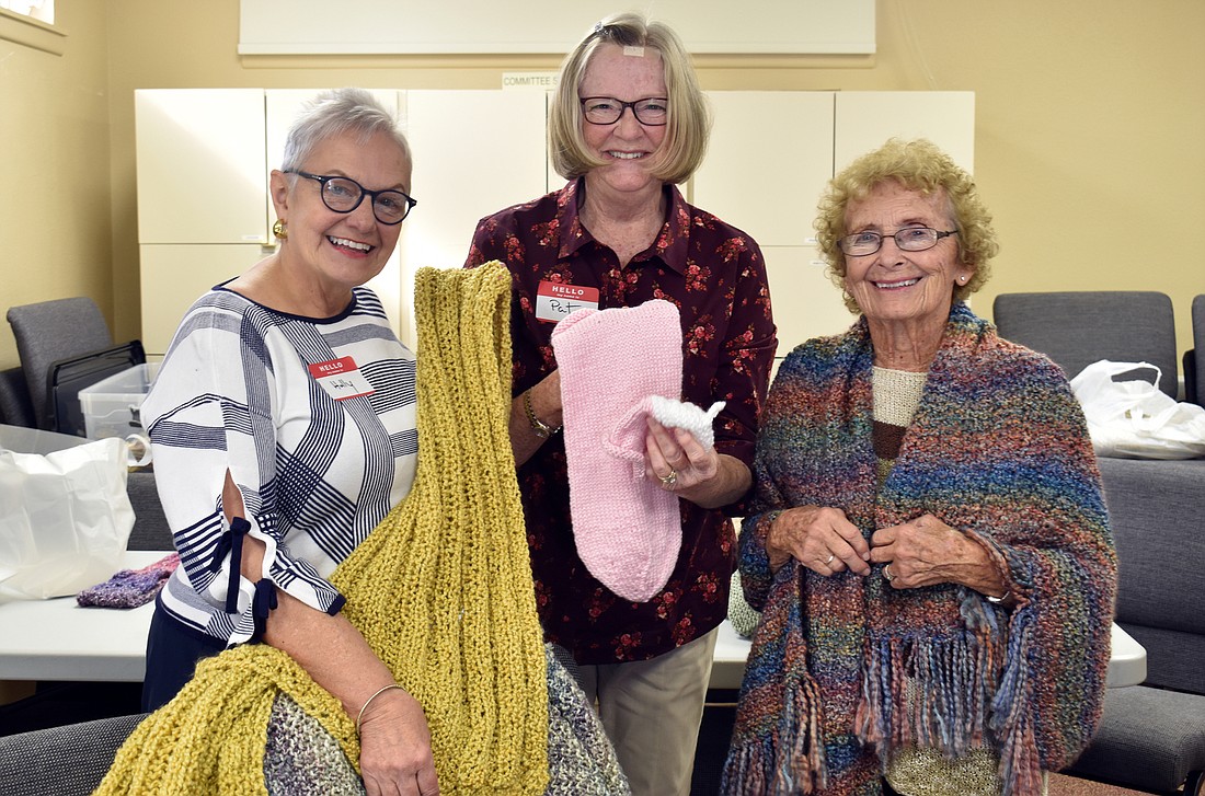Holly Finks, Pat Bergman and Snookie Register show off the creations of the Prayer Shawl Ministry.