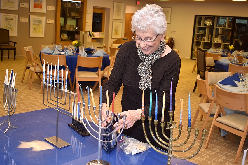 Judy Blume sets up her menorah. Temple members brought their personal menorahs and placed them together before the dinner.