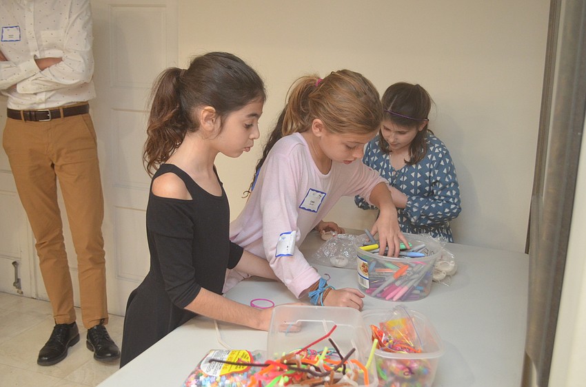 Ava Rosin and Emma Zoller play at the arts and crafts station.