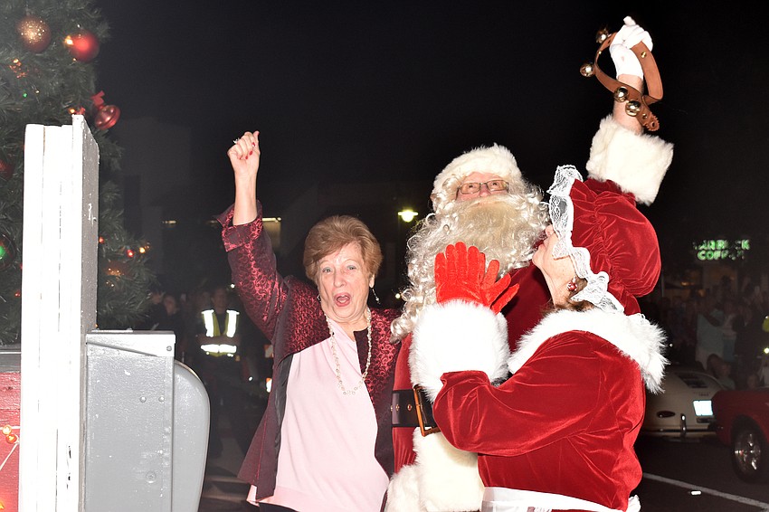 Iva Fadley-Dane of Wagner Realty cheers as she lights the tree with Santa and Mrs. Claus.