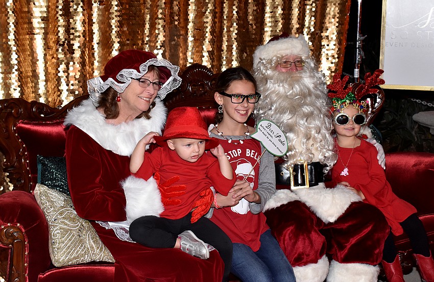 Vivienne Hansen, Emma Zamikoff and Marabella Hanses pose with Santa and Mrs. Claus.