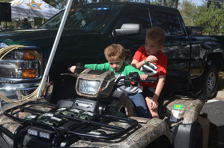 Daniel Bakondy and Matthew Bakondy sit on the four-wheeler used by the Sarasota Sheriff's Office.