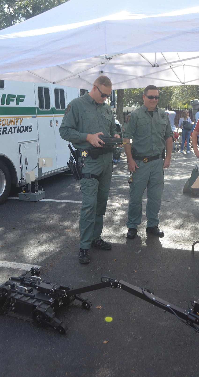 Deputies Robert Nicholas and Ed Hyde, from the bomb squad, show spectators how to use some of the robots.