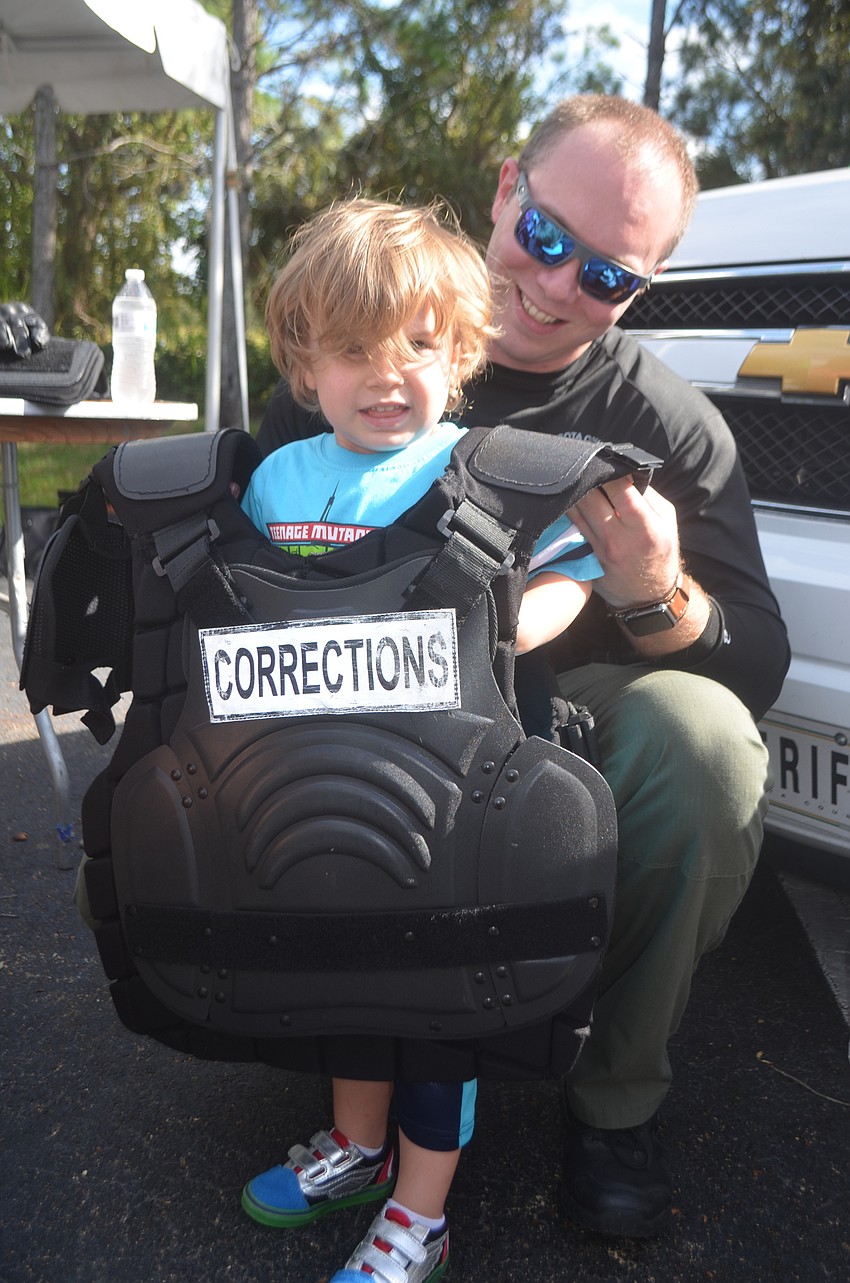 Jameson Goodwin tries on a bullet proof vest helped by Deputy Paul Eagans.