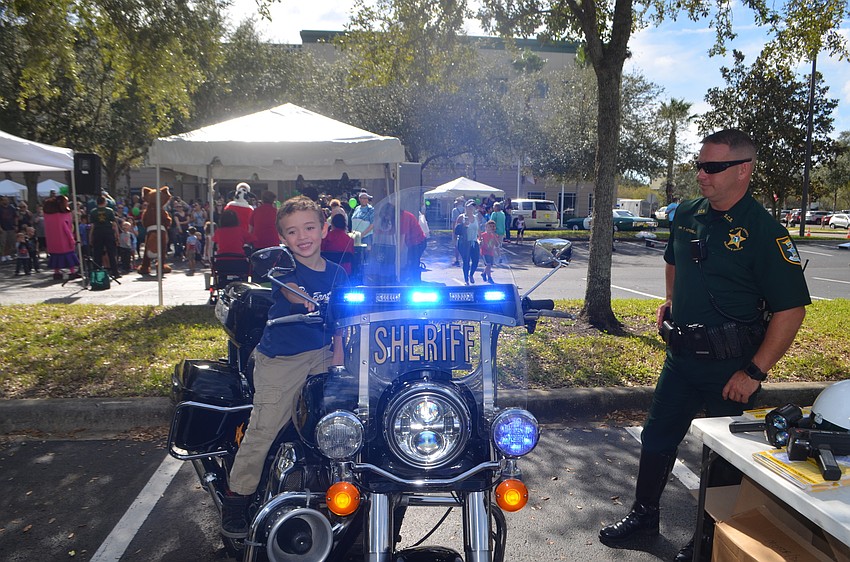 Jake Caraballo sits on Deputy Todd Mitchell's motorcycle.