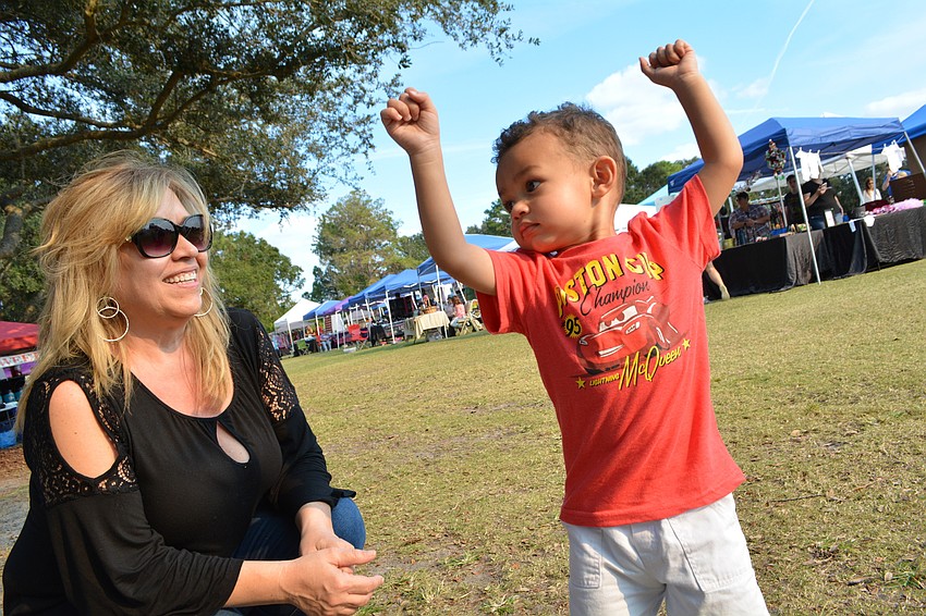 East County resident Robin Hall watches her 2-year-old grandson, Jaxon Ortega, dance to live music.