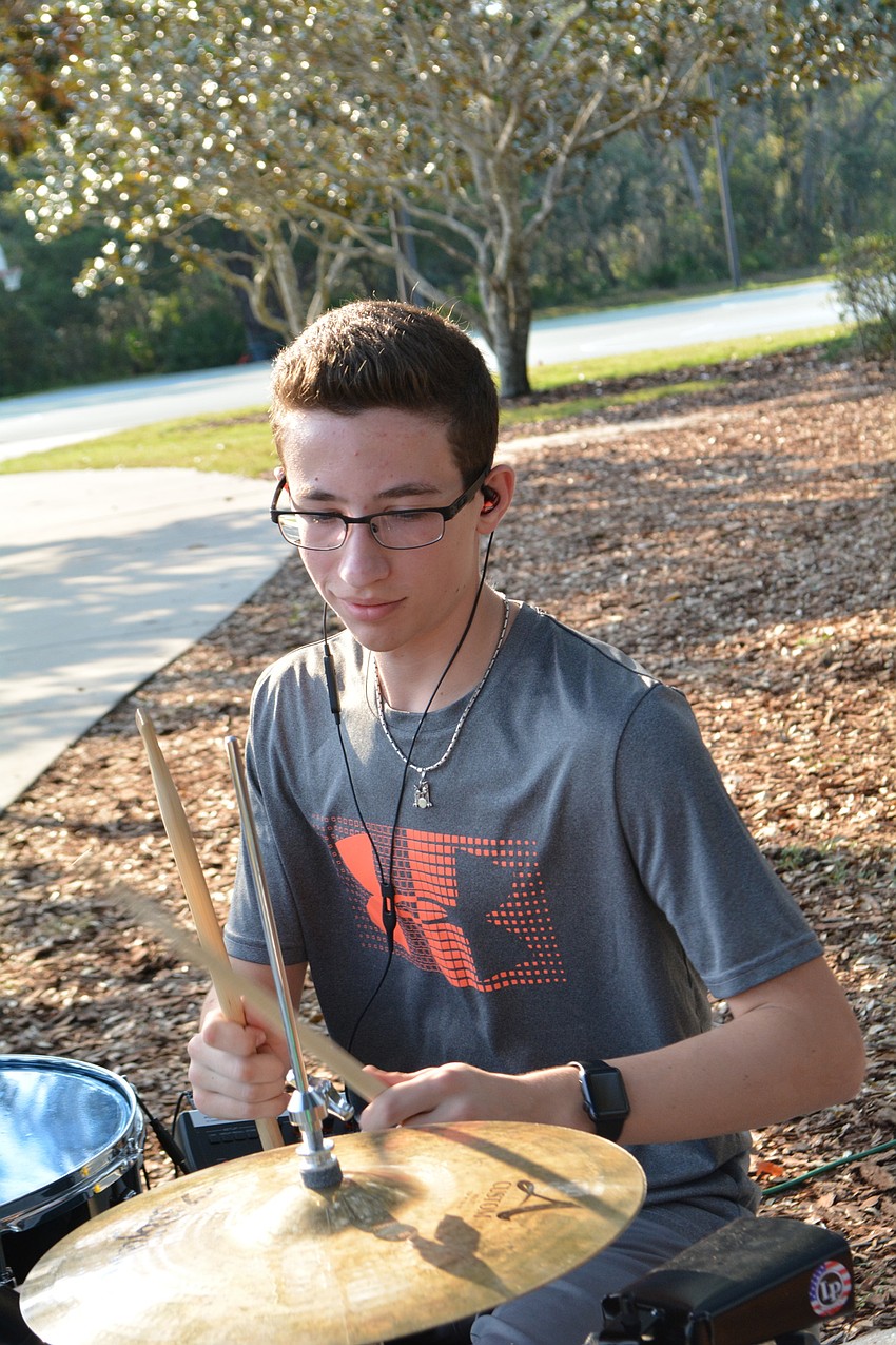Lakewood Ranch High School student Tyler STrum drums with the band JAKT for event-goers.