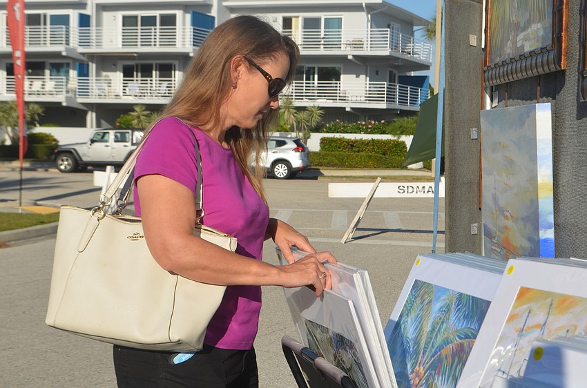 Kris Su peruses the art prints.
