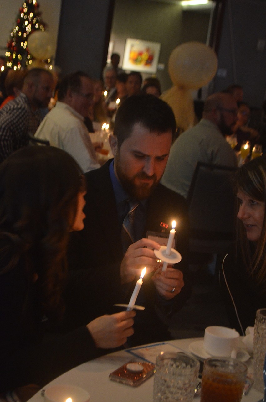 2019 Teacher of the Year Shane Swezey lights his candle, which represents the light that teachers bring to their community, at the end of the awards ceremony.