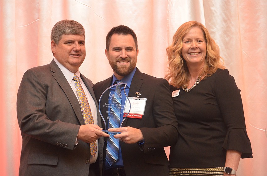Superintendent Todd Bowden presents the 2019  Teacher of the Year award to Shane Swezey, with Education Foundation President Jennifer Vigne.