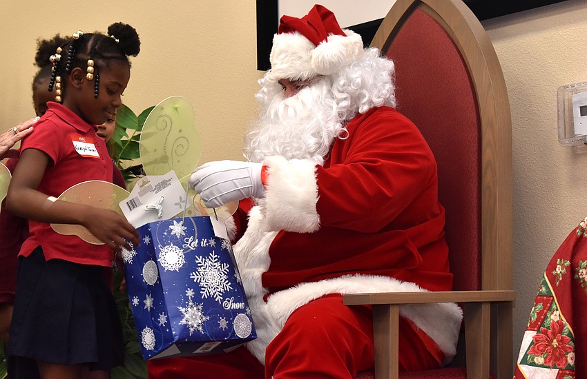 Tamia Munnings checks out the goody bag Santa gives her.