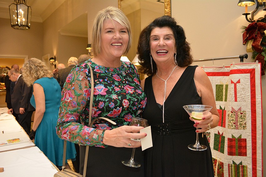 Kathy Wingfield and Sharon Wright check out a silent auction item in which they can win a pet portrait.