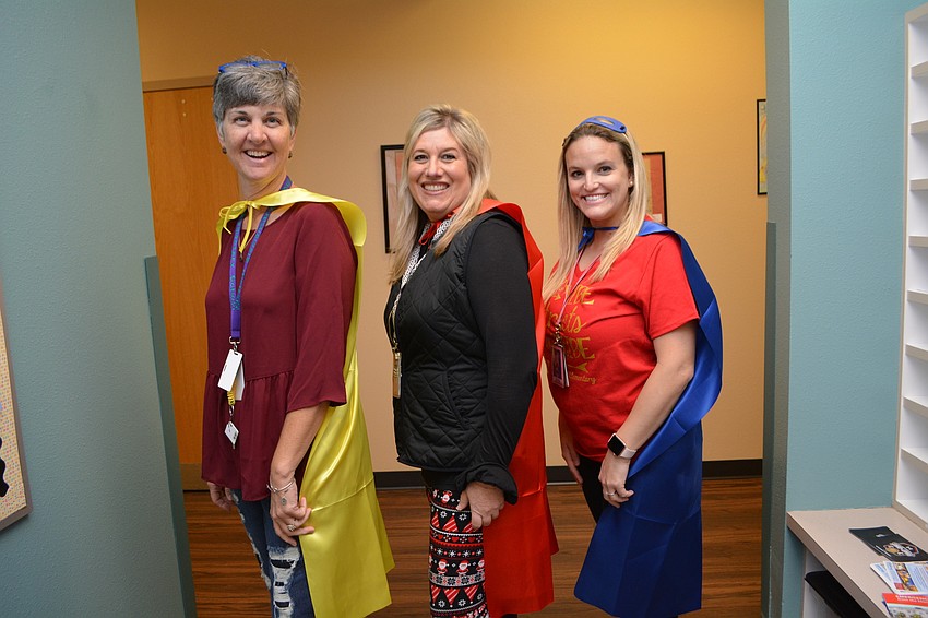 McNeal Elementary substitute Skoula Clark and second-grade teachers Angie Hughes and Jodi Samson love their capes.