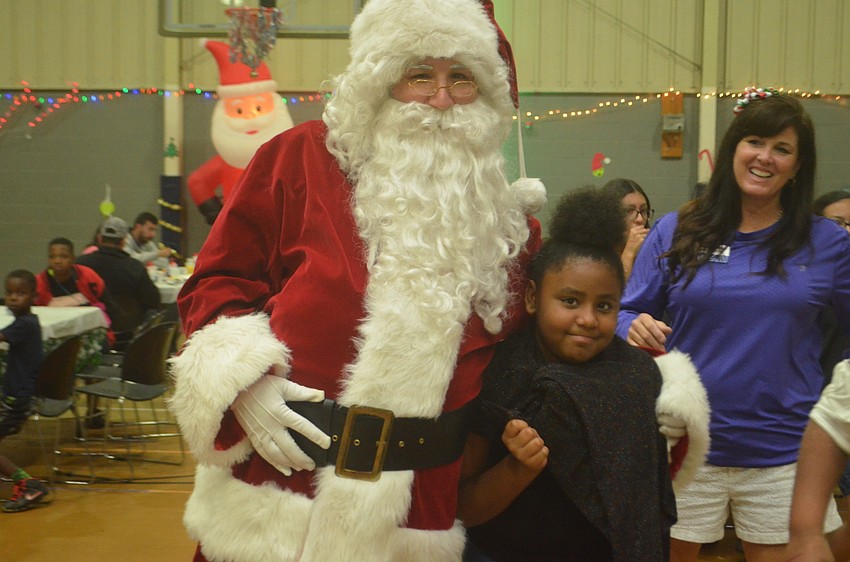 Santa gives Ciriya Shannon a hug when he walks in the door.