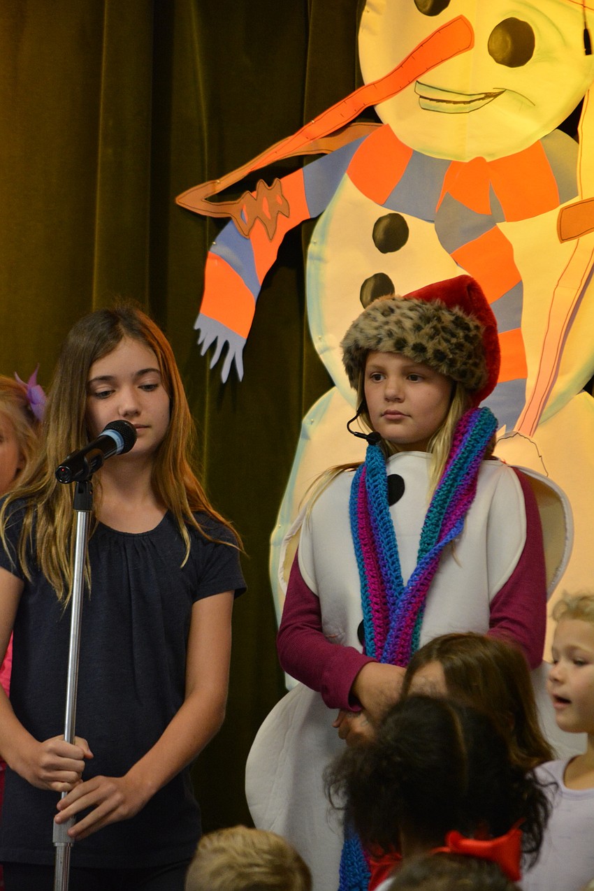 Fifth-grader Lucy Gehrke tells how Sneezy the Snowman, played by Autumn Pinion, was still cold after getting a scarf.