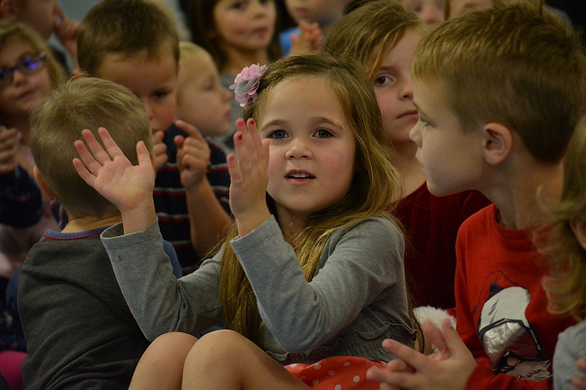 Pre-kindergartner Grace Foley, next to Carson Macek, is all smiles as kindergartners sing bout a snowman.
