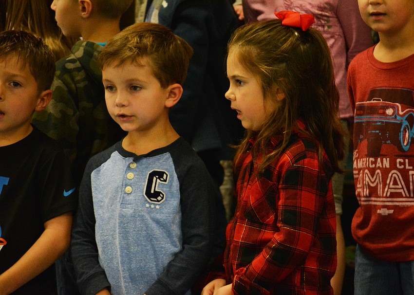 Kindergartners Grayson Rist and Nora Blasewitz have fun singing about Sneezy, who can never seem to get warm enough.