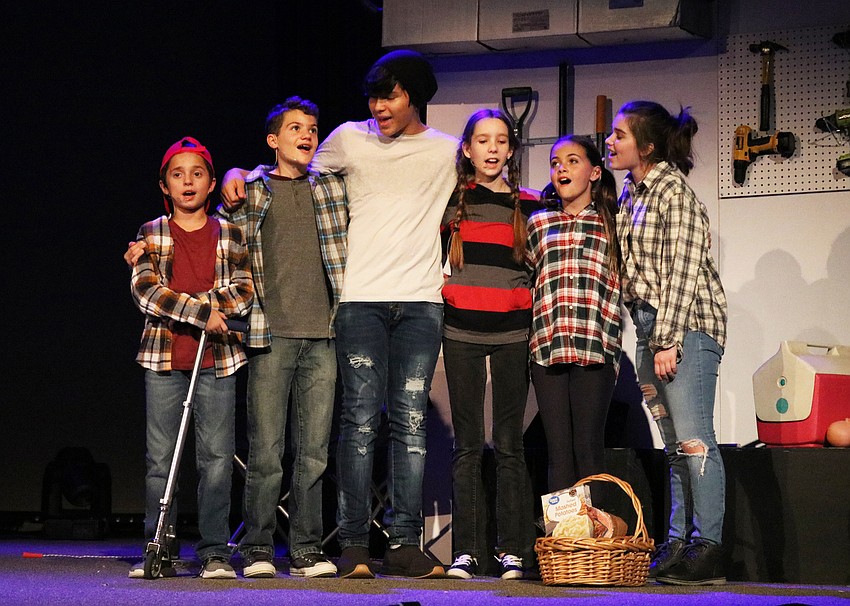 The Herdman children —Michael Sandwall, Federico Hradek, Marc Dalmau, Olivia Mueller, Addison Kolbe and Ashley Murnen — share a tender moment after getting a basket for the needy.  Photo by Debby Hradek.