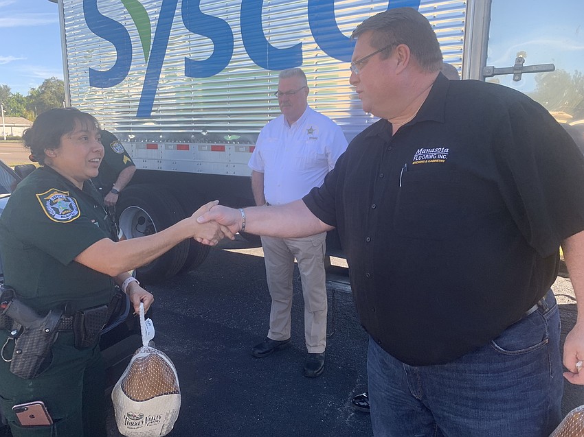 Deputy Leticia Leon shakes Chris Quattlebaum's hand.