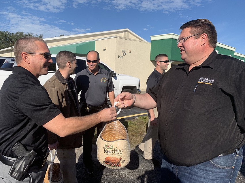 Gary Renninger accepts a turkey from Chris  Quattlebaum.