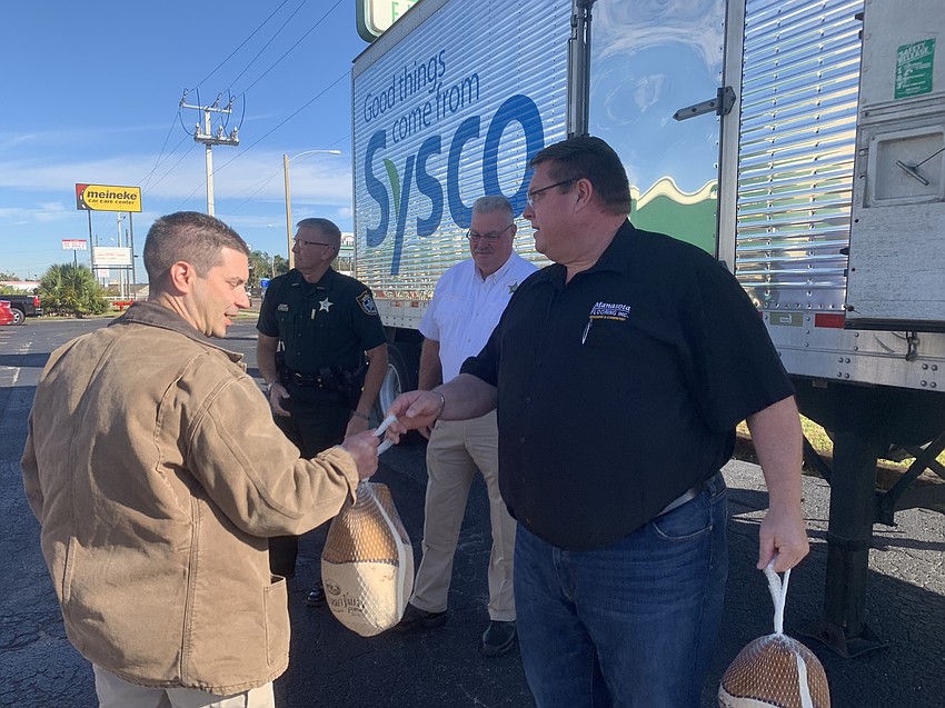 Deputy Garrick Plonczynski accepts a turkey from Christ Quattlebaum before his shift.
