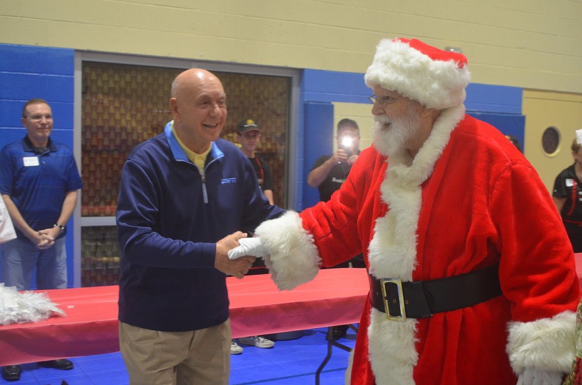 Dick Vitale gives Santa Claus a handshake.