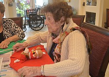 Isabel Decluccia glues down her stuffed dog on the front of her sweater.