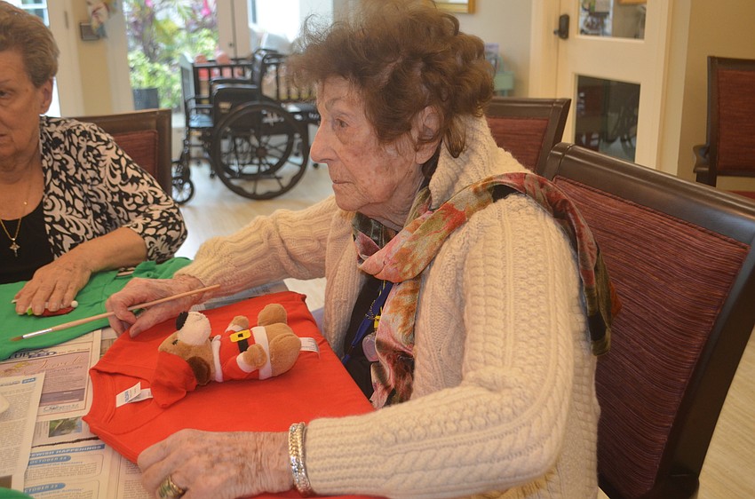 Isabel Decluccia glues down her stuffed dog on the front of her sweater.