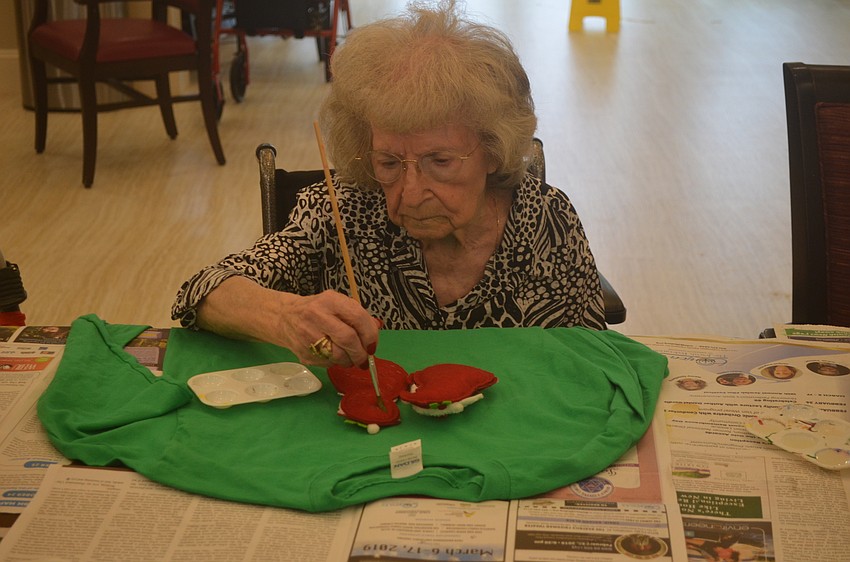 Theresa Giodano paints the back of her decorations.