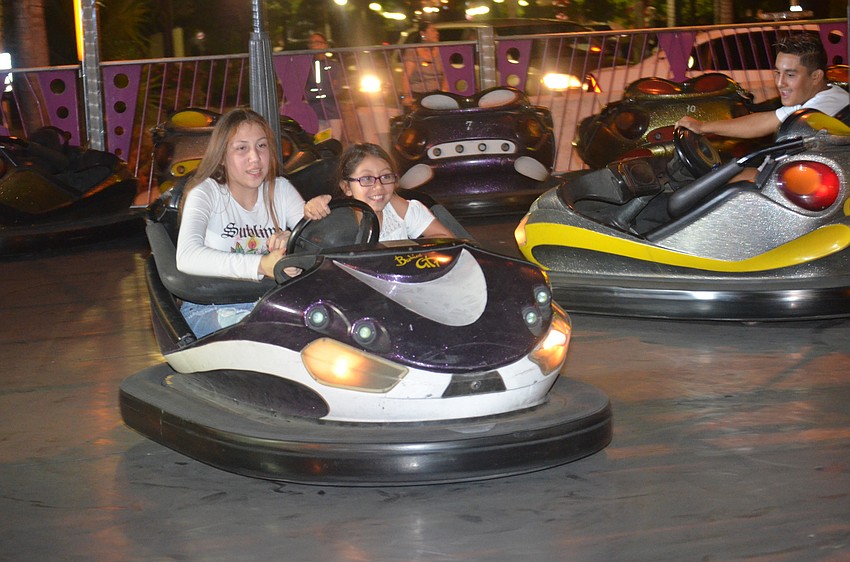 Alyssa Salinas and Emily Salinas drive bumper cars.