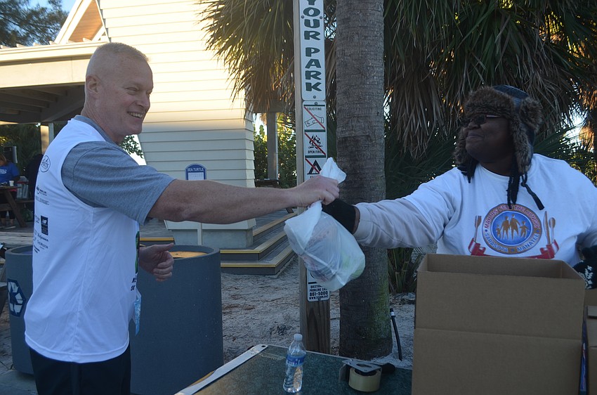 Lenny Sherry donates food to Mayor's Feed the Hungry, accepted by volunteer Tabitha Rentz.