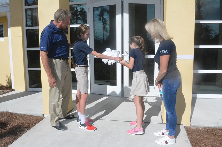 Zach and Sami Fox cut the Fox Field House ribbon as Larry and Jennifer Fox watch.
