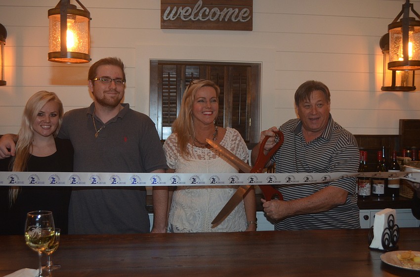 Kasey Gamble, Cole Gamble and co-owners Darlene Gamble and Stu Gamble cut the ribbon to the Siesta Key Wine Bar.