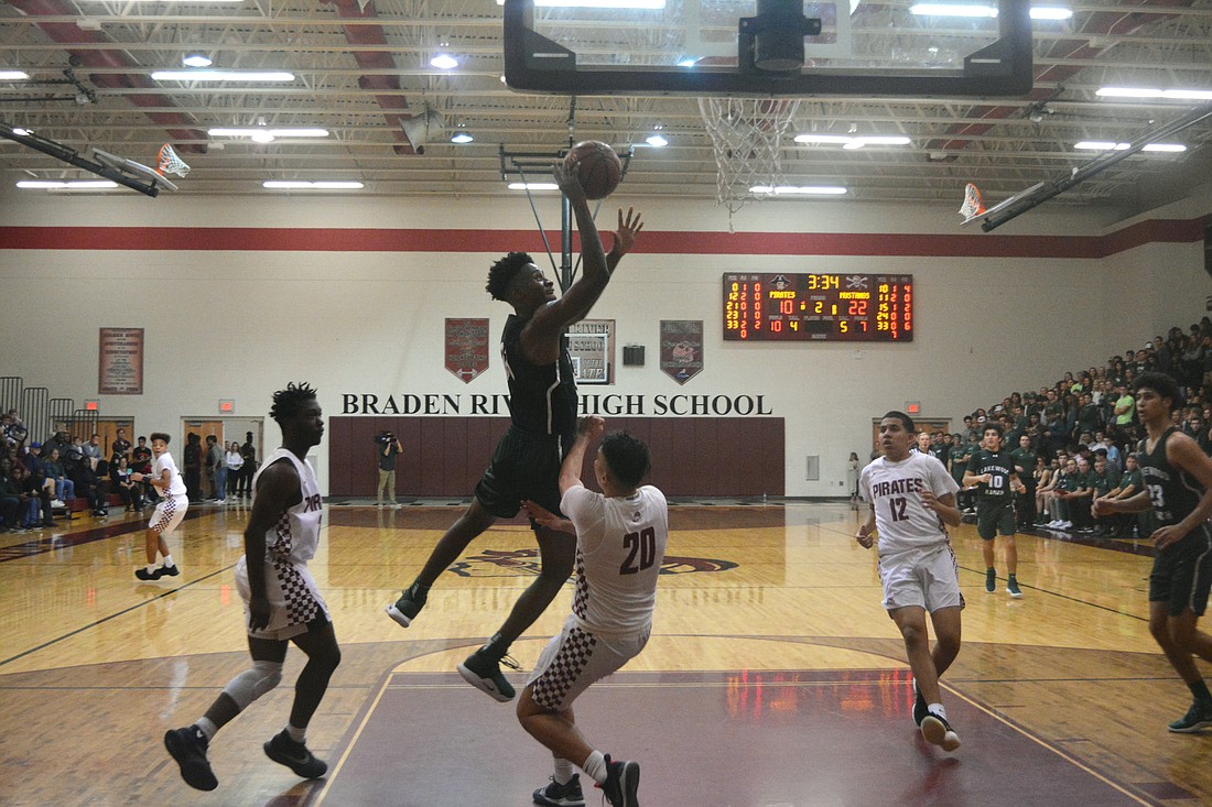 Mustangs senior forward Josh Young barrels into a Pirates defender on a drive to the basket.