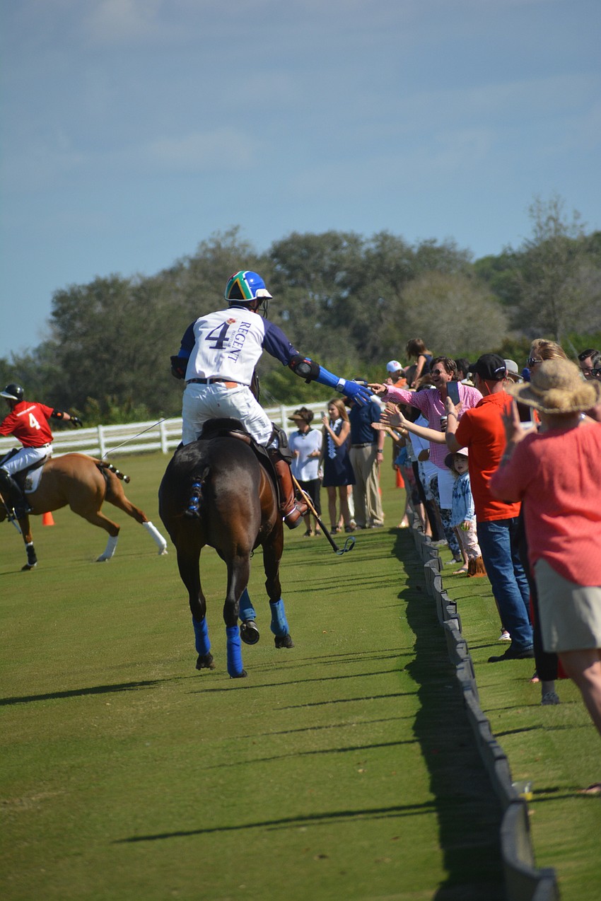 Wrigley Media's Stuart Campbell high-fives the fans before the match.