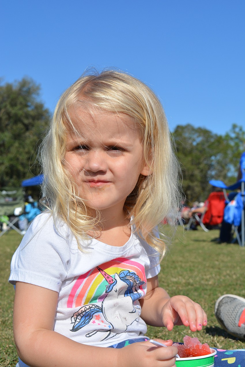 Two-year-old Nora Iturraspe, of Summerfield, enjoys Kona Ice while listening to music with her family and friends.