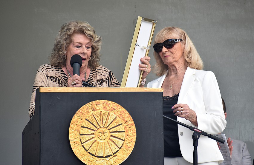 Kay Rosaire, the master of ceremonies, presents the plaque to Rosie Rode of the Rodos Troupe and Palace Duo.