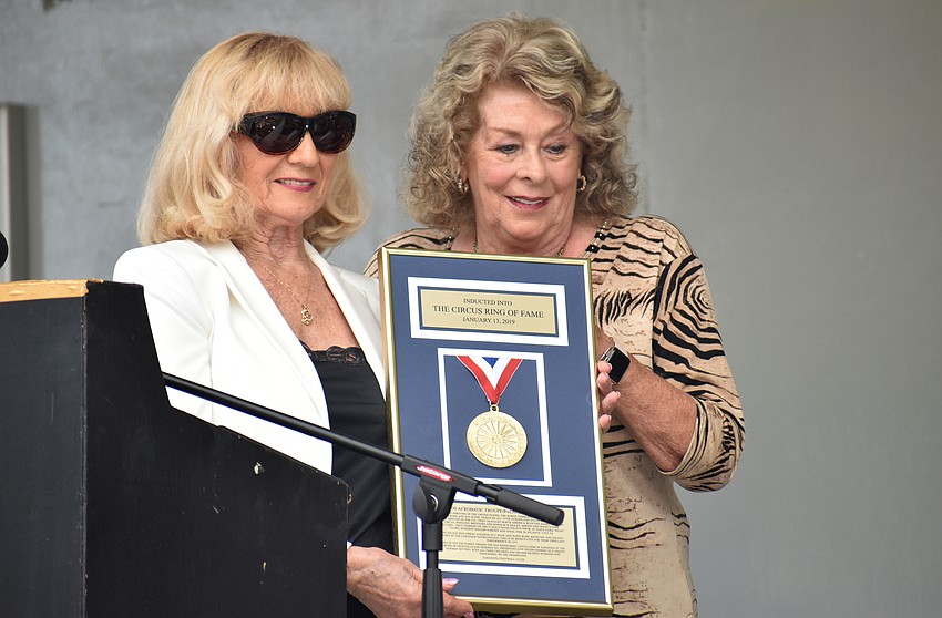 Kay Rosaire, the master of ceremonies, presents the plaque to Rosie Rode of the Rodos Troupe and Palace Duo.