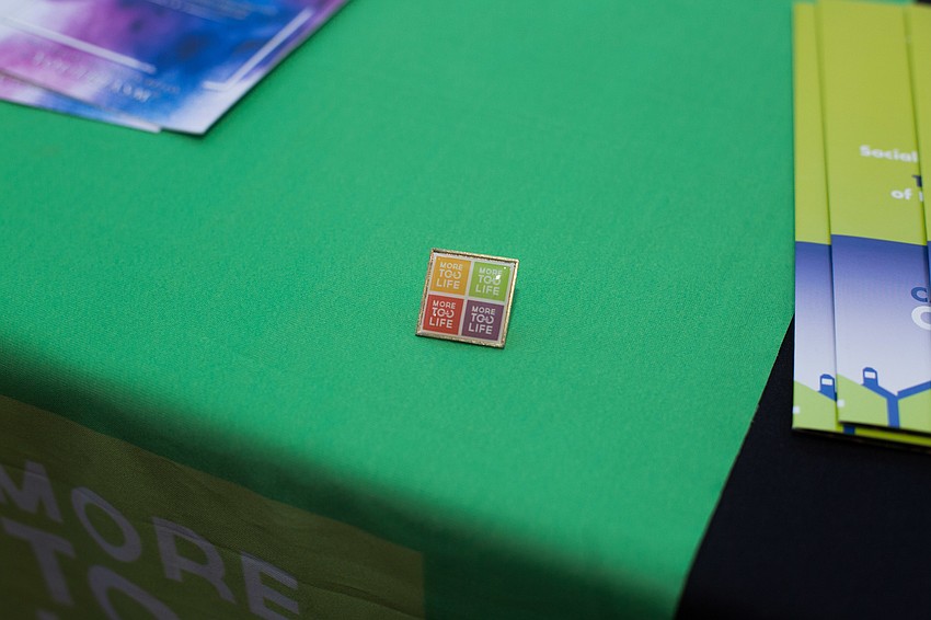 Supporters of the organization wore pins with the More Too Life logo.