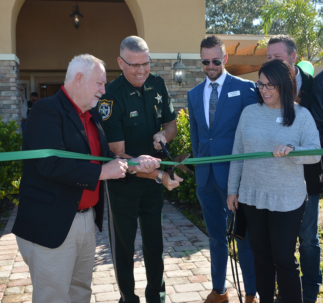 Schroeder-Manatee Ranch President and CEO Rex Jensen helps Sheriff Rick Wells cut the ribbon while Lennar&#39;s Craig Doehr and Linda Boos watch.