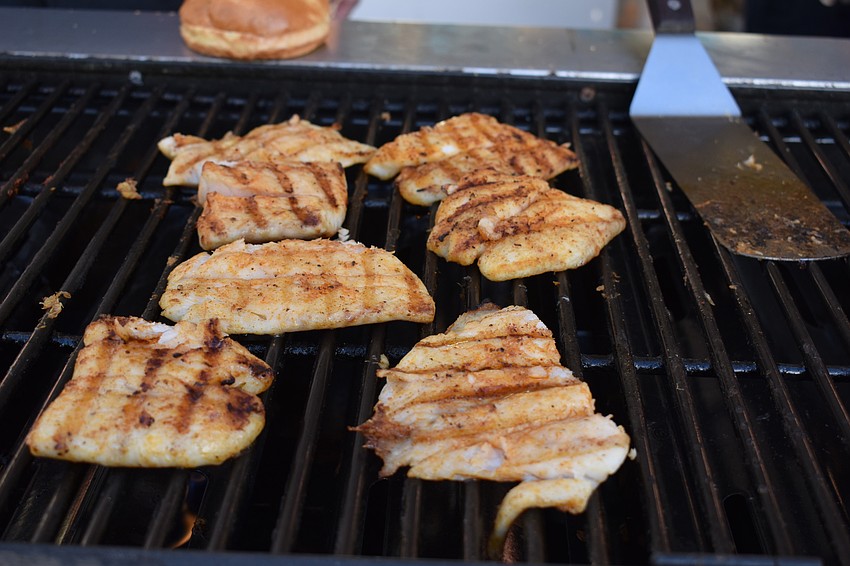 Tripletail cooks on the grill, prepared by Chef Rolf.